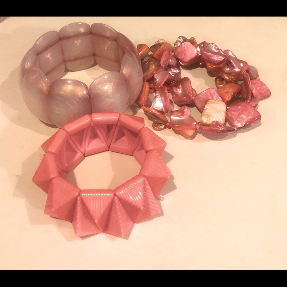 Three elastic bracelets in coral hues.